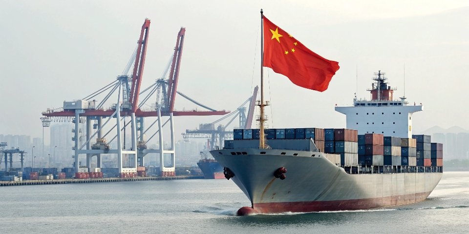 A cargo ship with South Korean and Chinese flags sailing from a Chinese port, representing the import-export relationship.