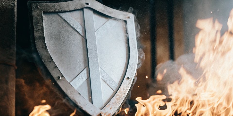 A shield deflecting flames, symbolizing fire retardancy.