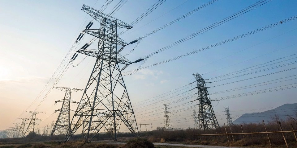 Massive electrical transmission towers standing against the sky, symbolizing industrial power.