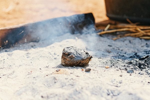 alt with keywords: A small, lumpy piece of melted and recrystallized aluminum found in the ashes of a fire