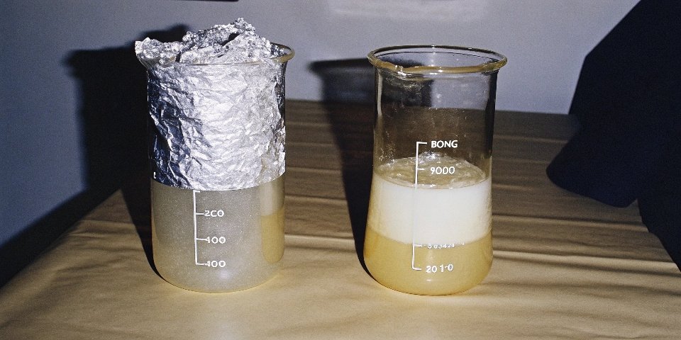Two side-by-side beakers, both with aluminum foil bubbling away. One is labeled 'Strong Acid (HCl)' and the other is 'Strong Base (NaOH)'.