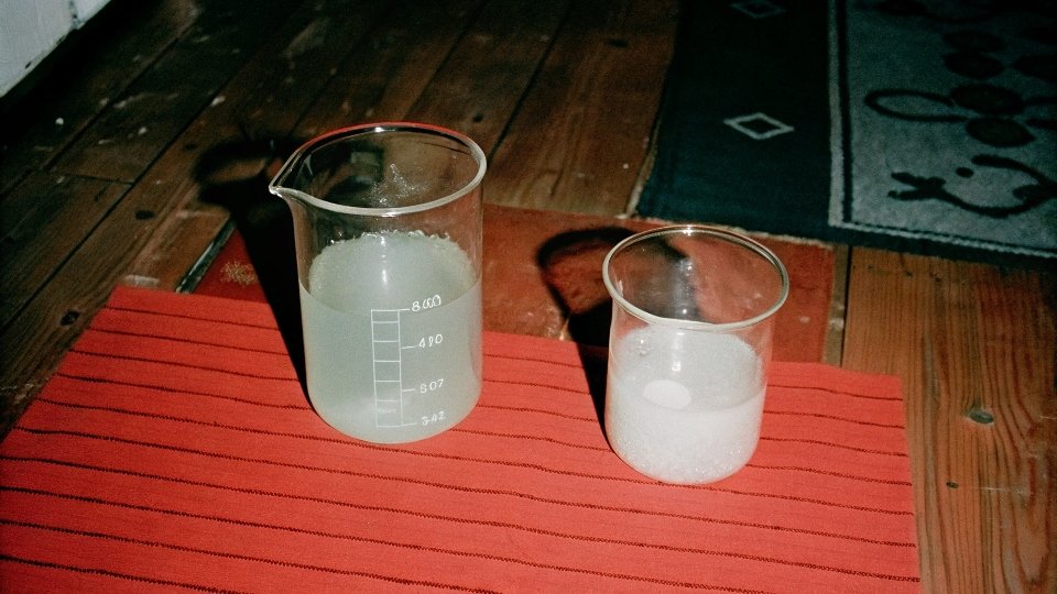 A two-part image: left beaker shows cloudy white Al(OH)3 suspended in water. Right beaker shows the same mixture turned perfectly clear after adding NaOH.