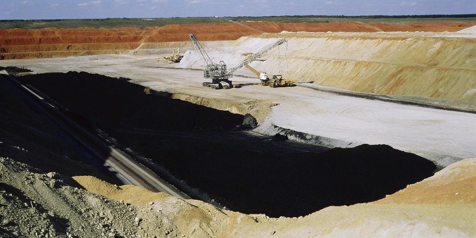 Open-pit bauxite mine with red earth and large machinery
