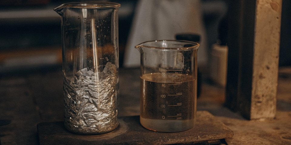 A piece of aluminum foil in two beakers, one with acid and one with base, both producing bubbles