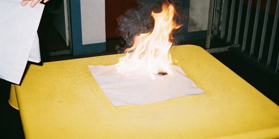 An image of a fire test being performed on a piece of plastic containing ATH, showing it charring instead of burning with large flames