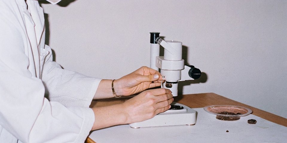 A laboratory technician analyzing a sample of bauxite ore