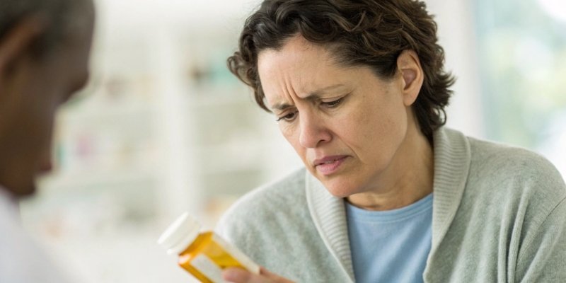 A person looking at a medication label with concern